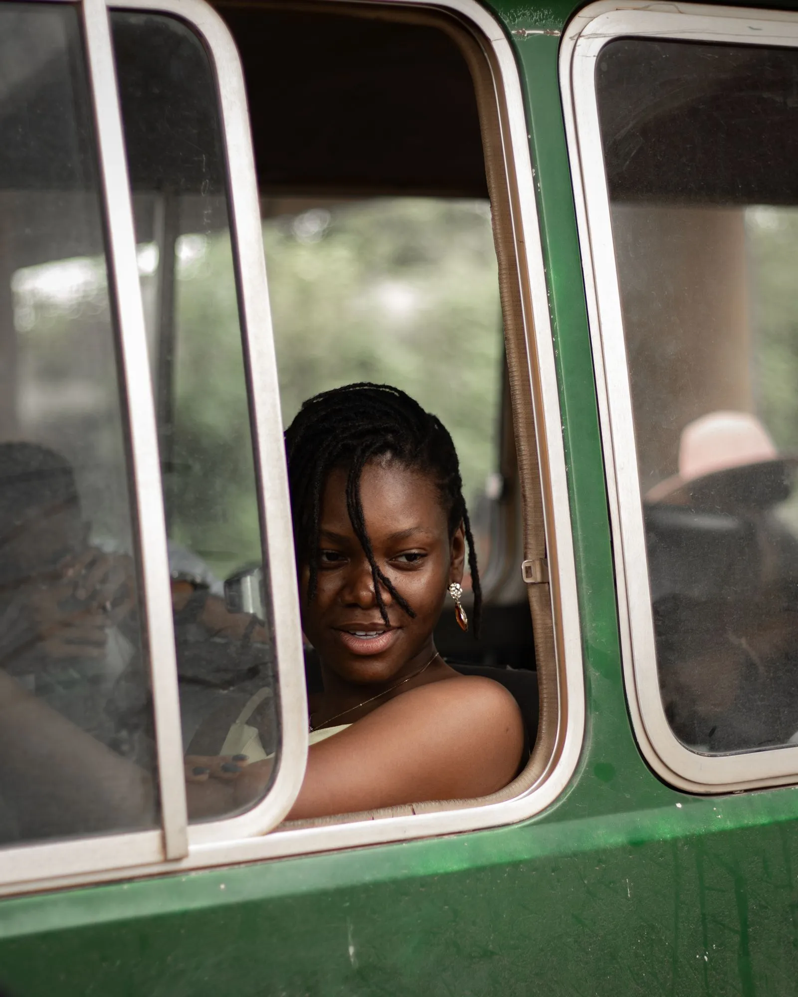 A young woman looking out from a bus window